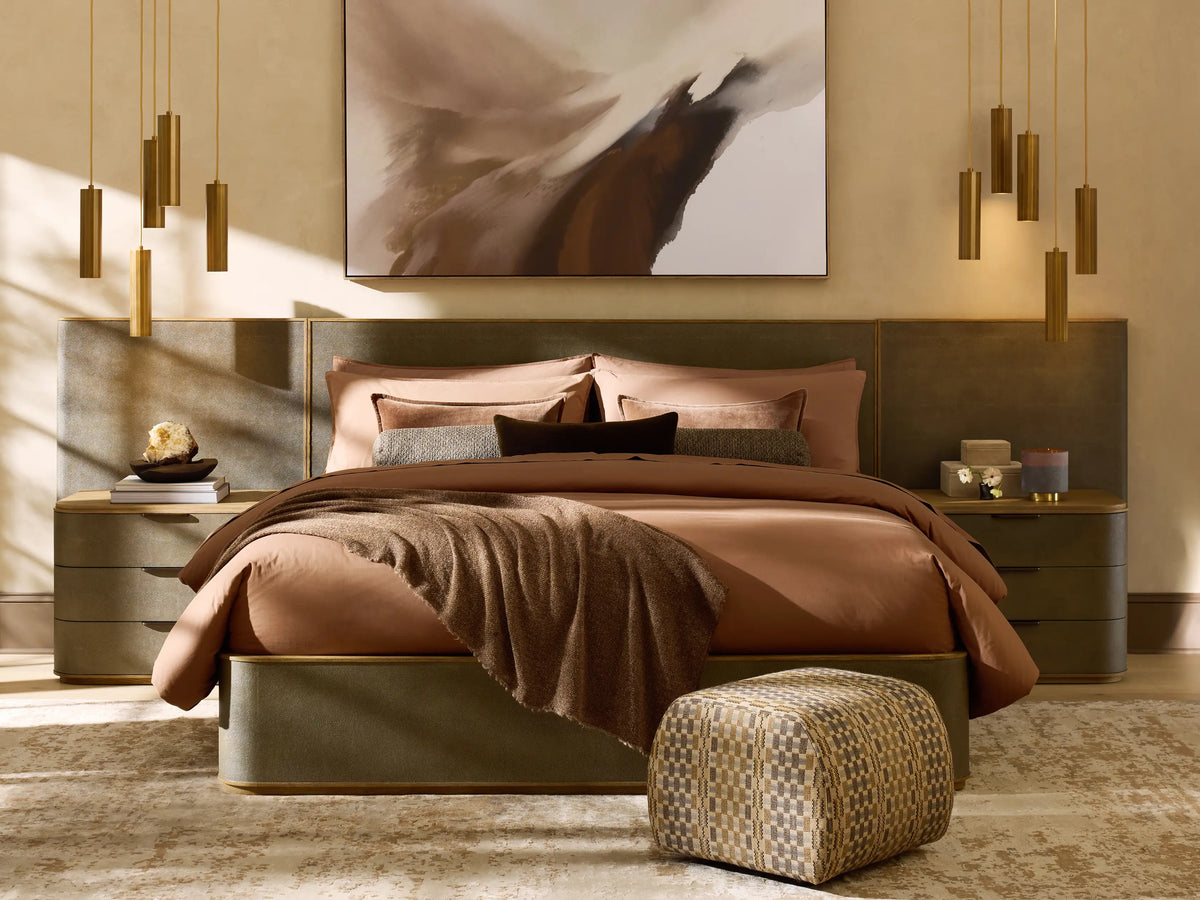 Rectangular ottoman with textured brown and white checkered fabric, placed on a wooden floor, against a beige wall.