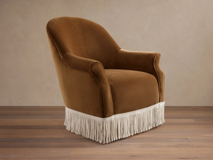Front view of a caramel Augustus Chair with Fringe, featuring rolled arms and a cream fringe along the bottom base.