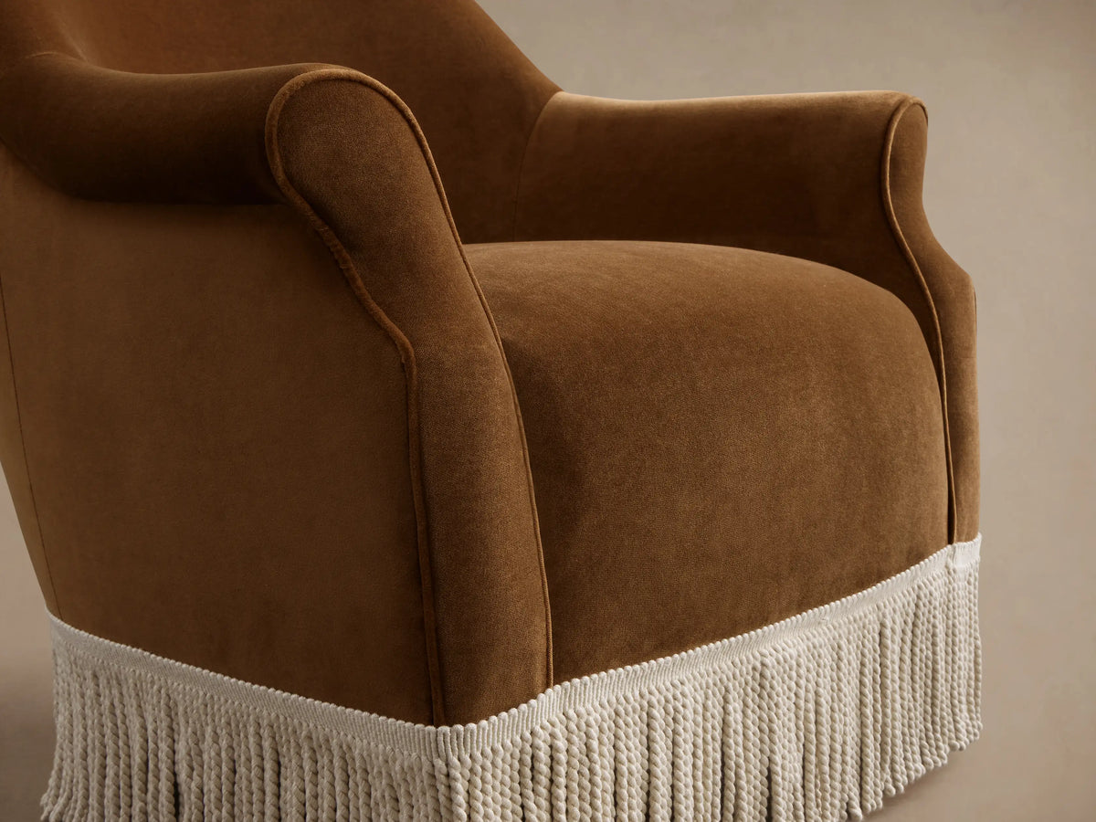 Front view of a brown velvet Augustus Chair with Fringe, featuring rolled arms and cream fringe trim.