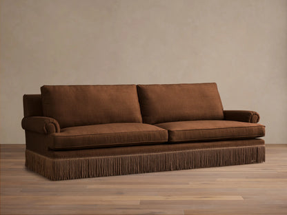 Front view of a brown McKinley Sofa with Fringe, featuring two seat cushions, rolled arms, and detailed brown fringe along the base.