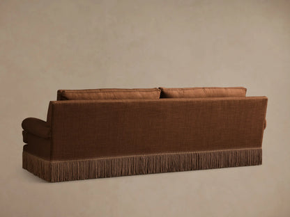 Rear view of the rust brown McKinley Sofa with Fringe, featuring two back cushions and a braided skirt fringe.