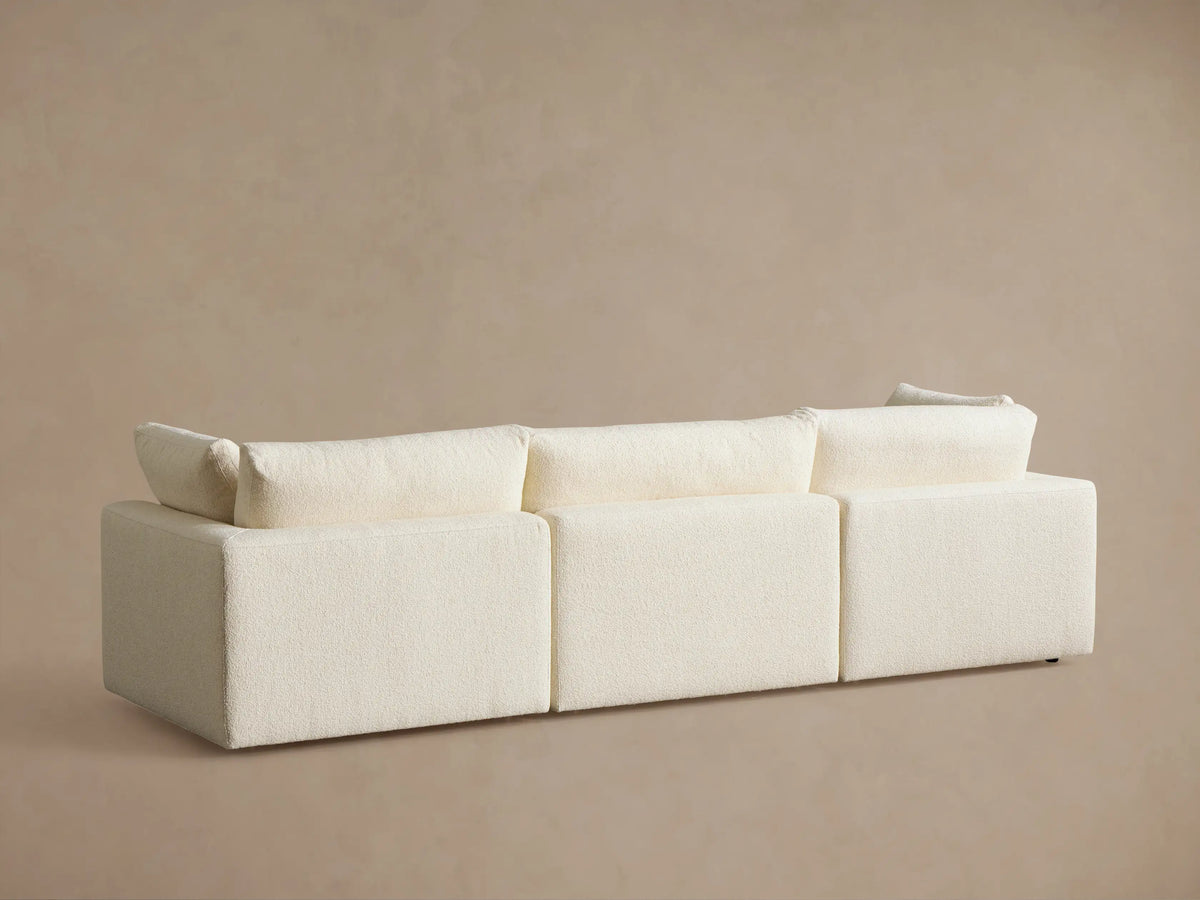 Close-up of a cream-colored Beale Modular Sofa, featuring a textured boucle fabric, thick armrest, and plush seat and back cushions.