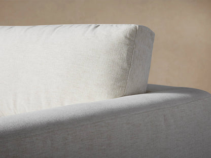 Light beige Beale Five Piece Sectional close-up. Plush back cushions, seat, and armrest in textured fabric.
