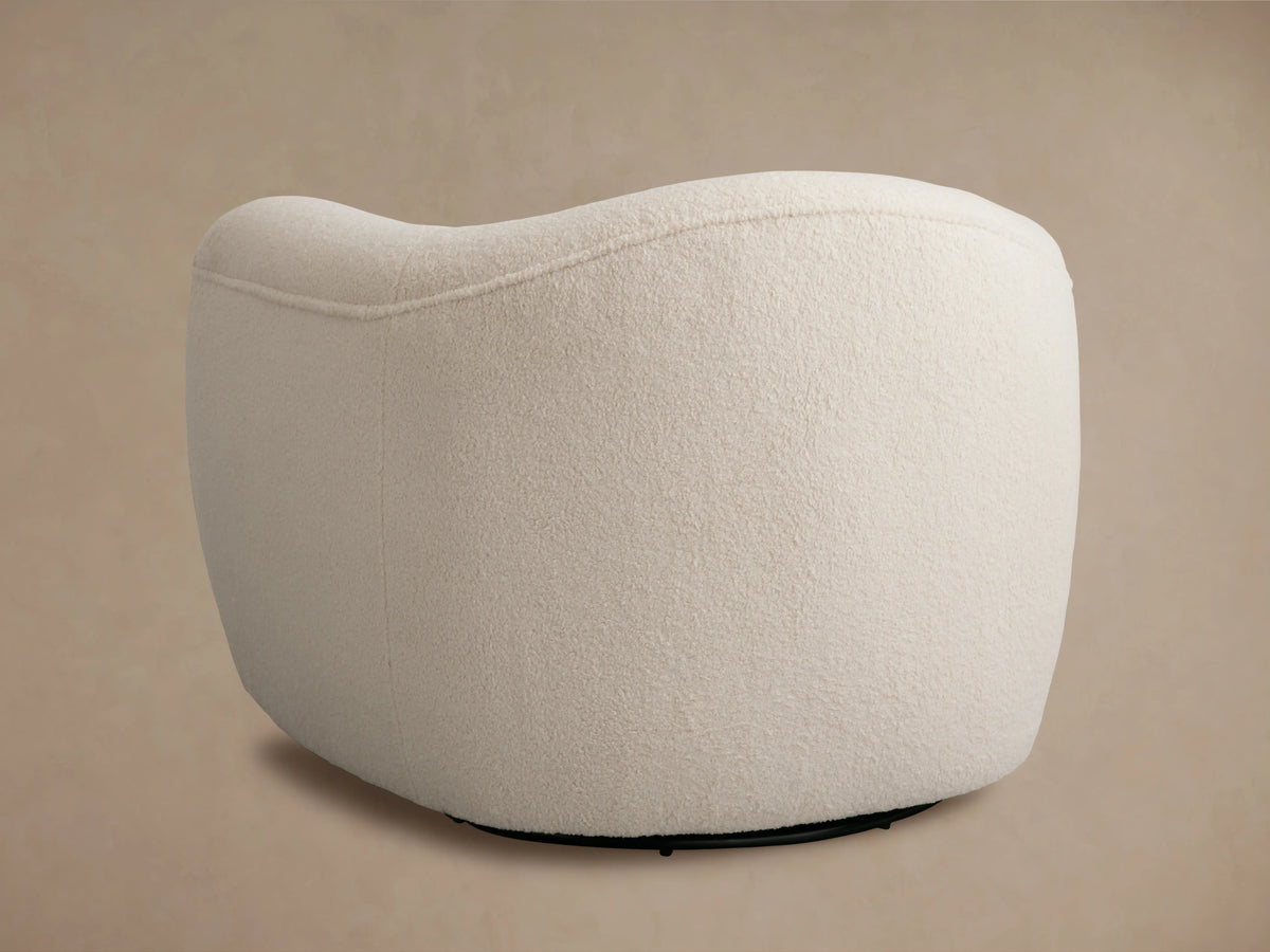Curved armrest of the Barret Chair in soft white textured fabric, showcasing plush cushioning and smooth contour.