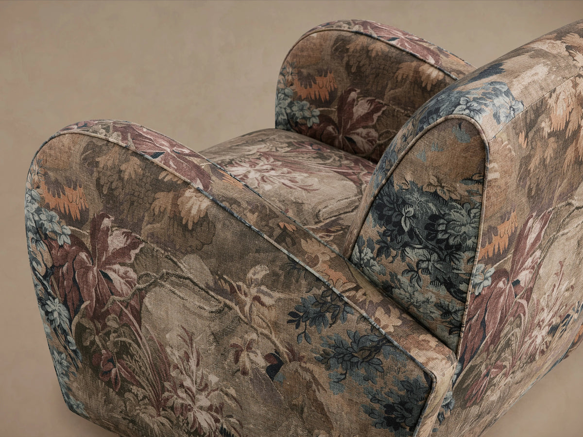 Front view of the Myrtle Chair with floral patterned upholstery in earthy tones, set on wooden legs, against a plain background.