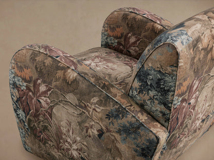 Front view of the Myrtle Chair with floral patterned upholstery in earthy tones, set on wooden legs, against a plain background.