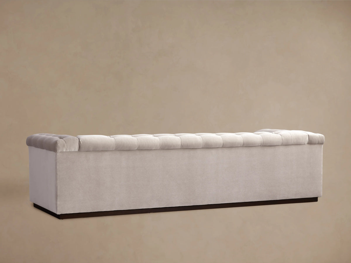 Cameran Sofa in light beige fabric, showcasing a tufted design on cushion and armrest, viewed in a close-up angle.