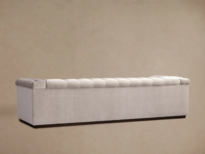 Cameran Sofa in light beige fabric, showcasing a tufted design on cushion and armrest, viewed in a close-up angle.