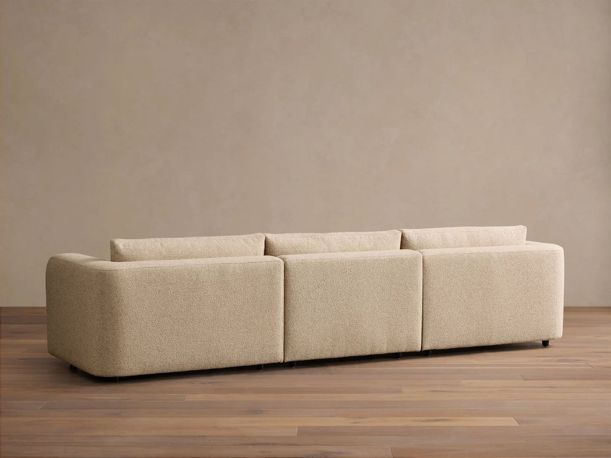 Rear view of the beige Stiles Three-Piece Modular Sofa, showing its three modular sections and textured fabric.