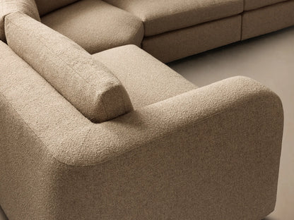 Front view of the tan textured woven fabric Stiles Four-Piece Sectional, with low-profile arms and back cushions, arranged in an L-shape.