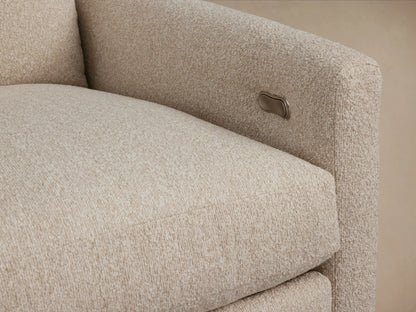 Kipton Motion Recliner in a beige fabric, featuring slim arms and a plush cushion, set on a wooden floor against a neutral wall.