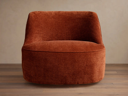 Sonny Swivel Chair upholstered in rust orange ribbed corduroy fabric, angled front-left, with a curved back and round base.