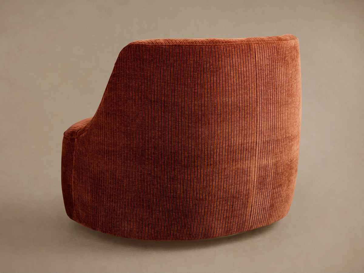 Sonny Swivel Chair: Angled close-up of the chair in burnt orange ribbed corduroy fabric, showing its curved backrest and seat.
