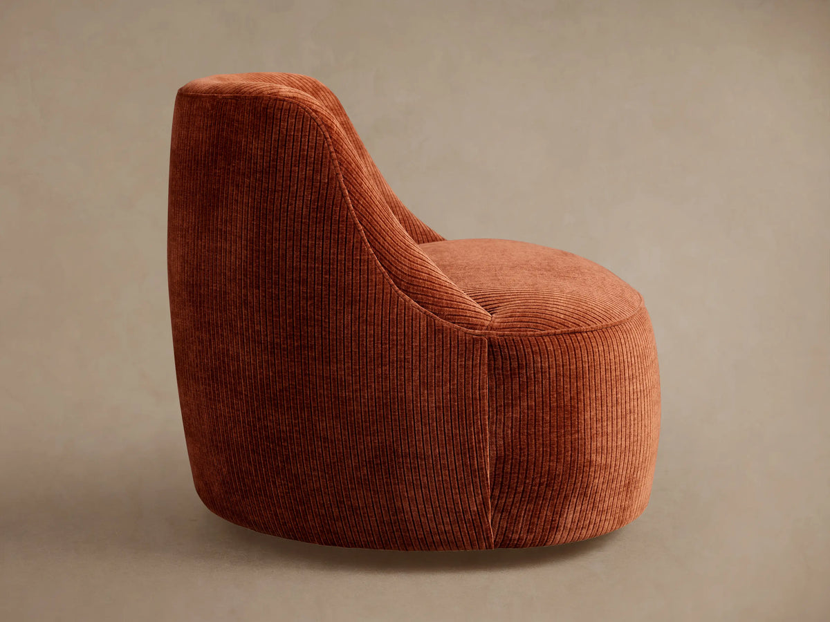 Sonny Swivel Chair, rear-side view, upholstered in rust-orange corduroy fabric with visible vertical ribs, modern curved design.