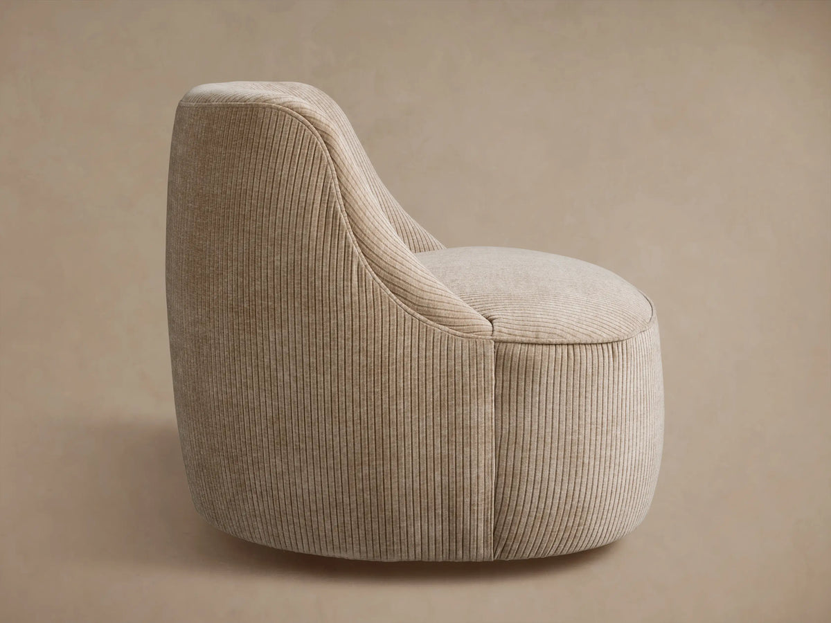 Back view of a beige ribbed Sonny Swivel Chair, slightly angled right, against a neutral light brown background.