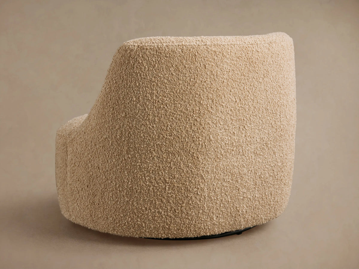 Close-up of Sonny Swivel Chair's seat and curved back/arm in textured light beige boucle fabric with subtle variations.