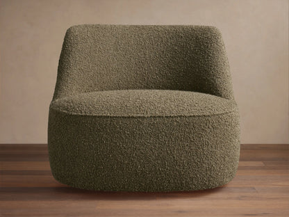 Textured olive green Sonny Swivel Chair, armless with a curved back & wide round base, sitting on a wooden floor.
