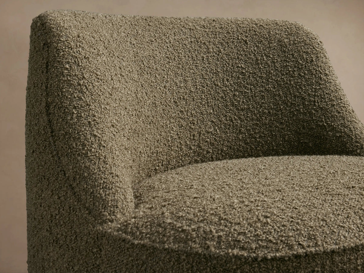 Rounded armless Sonny Swivel Chair, upholstered in moss green textured bouclé fabric, shown from the front.