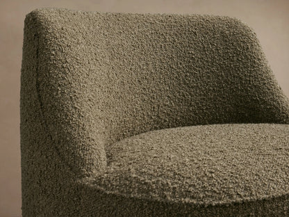 Rounded armless Sonny Swivel Chair, upholstered in moss green textured bouclé fabric, shown from the front.