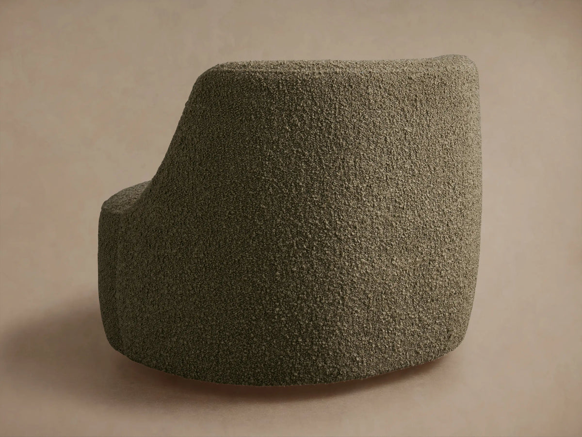 Sonny Swivel Chair close-up, showing its curved back & seat in textured, muted olive green bouclé upholstery.