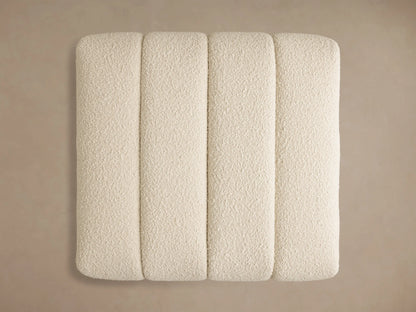Top-down view of the off-white Bracco Ottoman with four vertical channels and a textured, nubbly fabric finish.