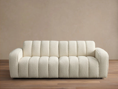 Front view of the cream Bracco Two-Piece Sofa, featuring a soft textured bouclv© fabric and distinctive vertical channel tufting.