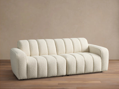 Front view of the cream Bracco Two-Piece Sofa, featuring a soft textured bouclv© fabric and distinctive vertical channel tufting.
