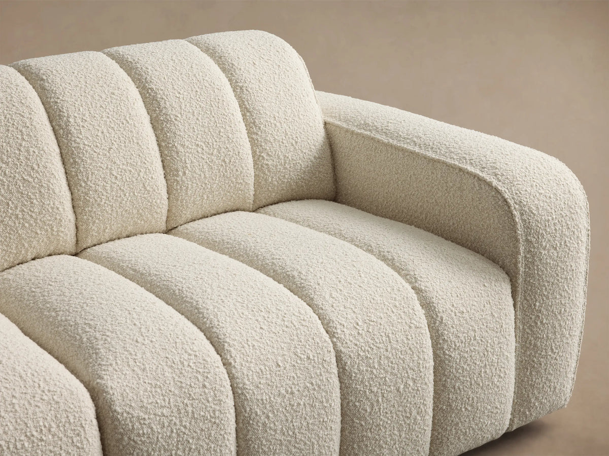 Front view of a cream Bracco Two-Piece Sofa, featuring vertical channel tufting and a textured bouclv©-style fabric.