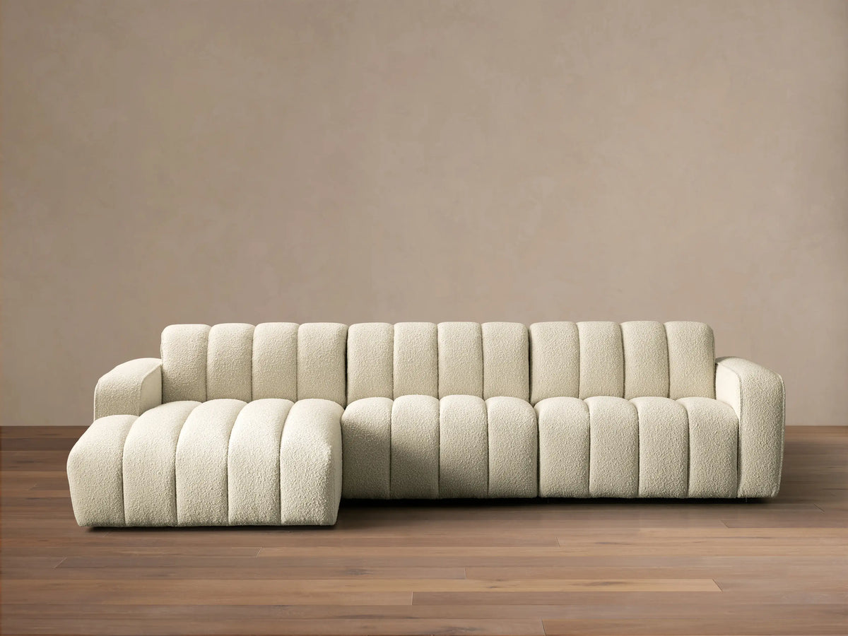 Front view of cream channel-tufted Bracco Three-Piece Chaise Sectional with a left-side chaise on a wooden floor.