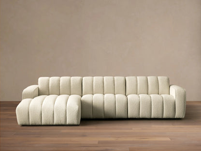 Front view of cream channel-tufted Bracco Three-Piece Chaise Sectional with a left-side chaise on a wooden floor.