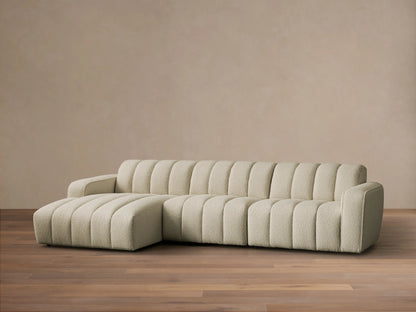 Front view of cream channel-tufted Bracco Three-Piece Chaise Sectional with a left-side chaise on a wooden floor.