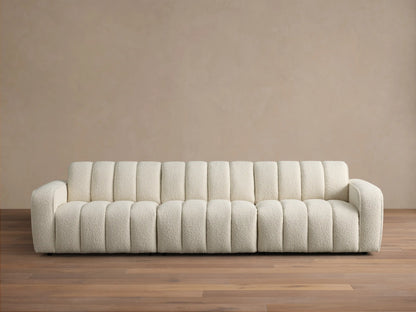 Front view of the cream Bracco Three-Piece Modular Sofa, featuring a textured bouclv© fabric and distinct vertical channeling.
