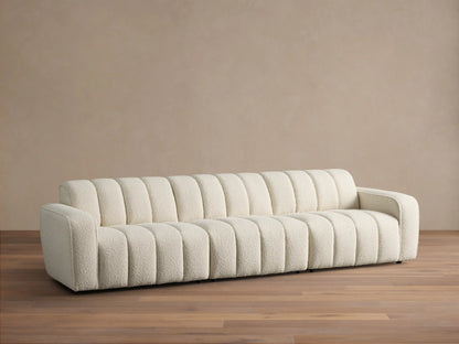 Front view of the cream Bracco Three-Piece Modular Sofa, featuring a textured bouclv© fabric and distinct vertical channeling.
