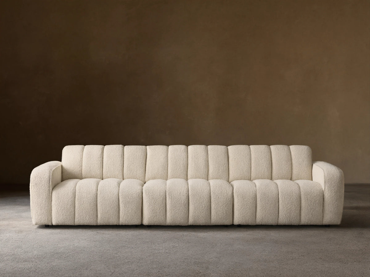 Front view of the cream Bracco Three-Piece Modular Sofa, featuring a textured bouclv© fabric and distinct vertical channeling.