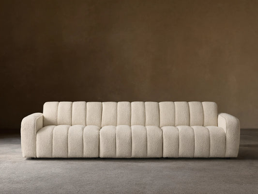 Front view of the cream Bracco Three-Piece Modular Sofa, featuring a textured bouclv© fabric and distinct vertical channeling.