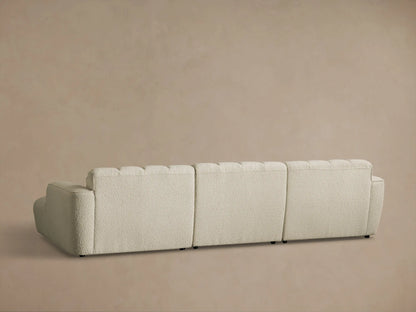 Rear view of the cream textured Bracco Three-Piece Chaise Sectional with segmented, tufted back cushions.