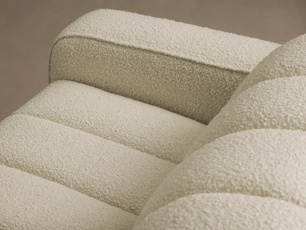 Close-up of the cream bouclé-style textured fabric on the Bracco Three-Piece Chaise Sectional, featuring horizontal channeling.
