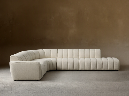 Front view of Cream Bracco Five-Piece Bumper Sectional with channel tufting, curved, on a wooden floor.