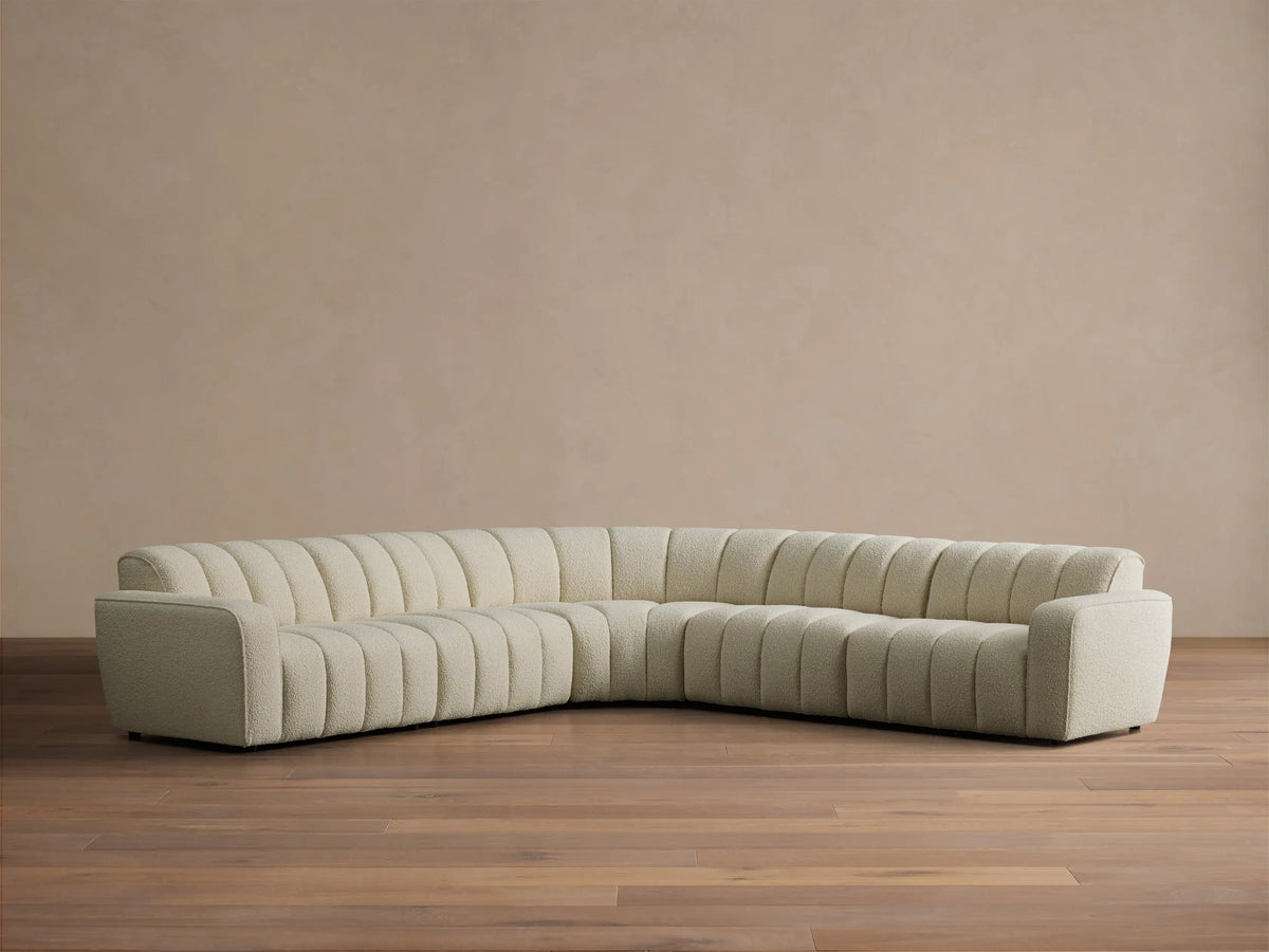 Front view of the cream Bracco Five-Piece Corner Sectional, an L-shaped sofa with channel tufting and textured fabric.