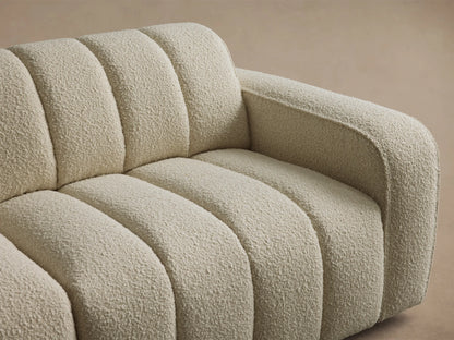 Front view of the cream Bracco Five-Piece Corner Sectional with channeled upholstery on a wooden floor.