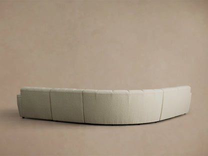 Close-up, angled view of the cream Bracco Five-Piece Corner Sectional, showing vertical channeling and a curved armrest with textured fabric.