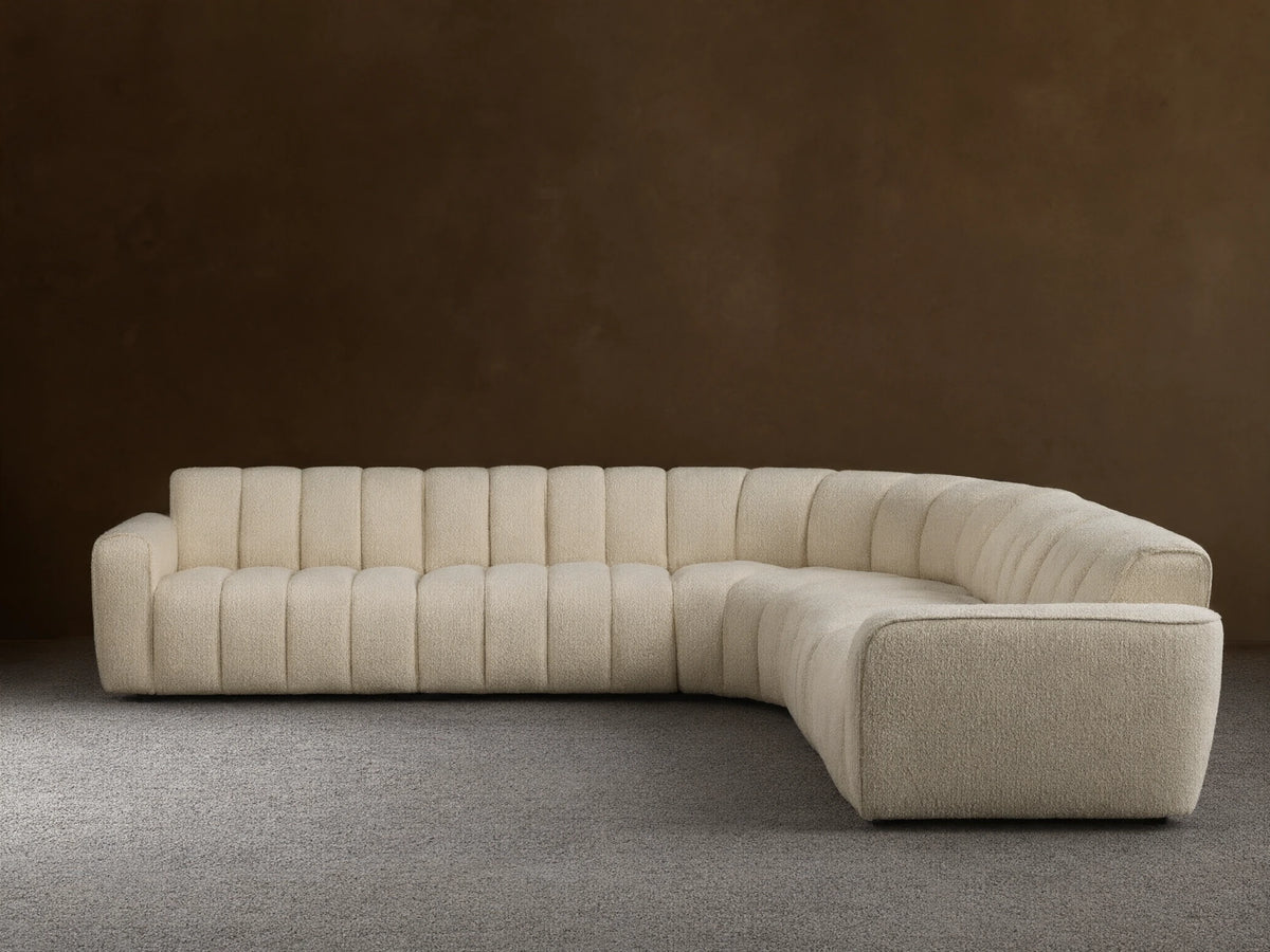 Front view of the cream Bracco Five-Piece Corner Sectional, an L-shaped sofa with channel tufting and textured fabric.