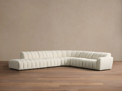 Front view of the cream Bracco Five-Piece Bumper Sectional, L-shaped with vertical channel tufting and boucle fabric.