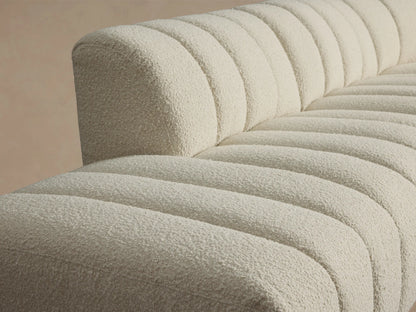 Front view of the cream Bracco Five-Piece Bumper Sectional, an L-shaped sofa with vertical channel tufting.