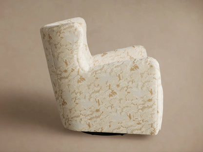 Sasha Swivel Chair with cream fabric & gold botanical pattern, viewed from back-left. Dark swivel base visible.