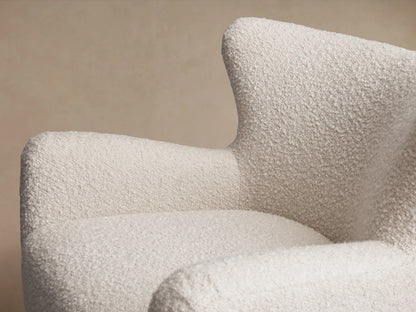 Sasha Swivel Chair in textured cream fabric on wooden floor, with curved armrests, high backrest, and 360-degree swivel base.