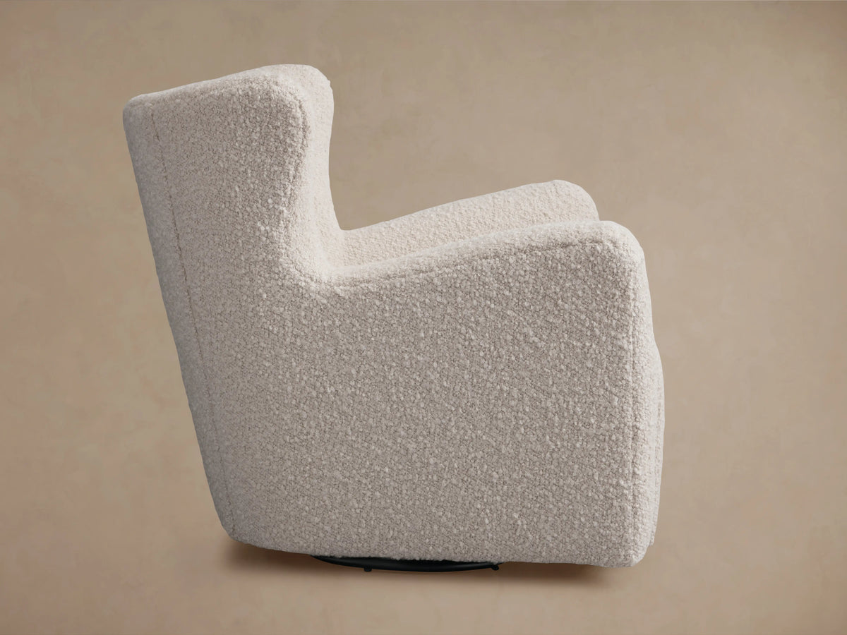 Cream-colored Sasha Swivel Chair with textured upholstery, featuring curved armrests and a plush backrest against a neutral background.