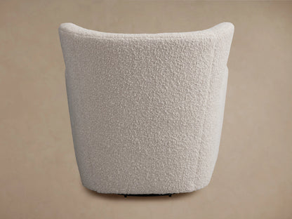 Sasha Swivel Chair in beige textured fabric, angled view. Curved backrest, visible seam, and black swivel base.