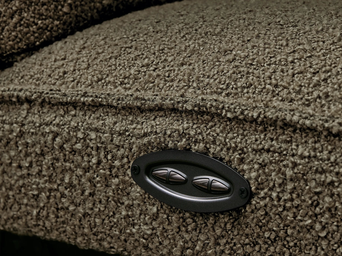 Close-up of brown, plush Coburn Six-Piece Motion Sectional. One backrest is reclined, and a footrest is partially elevated.