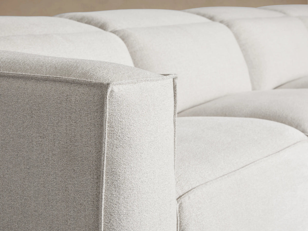 Close-up of the beige textured fabric seat cushion and backrest of the Coburn Five-Piece Motion Corner Sectional.